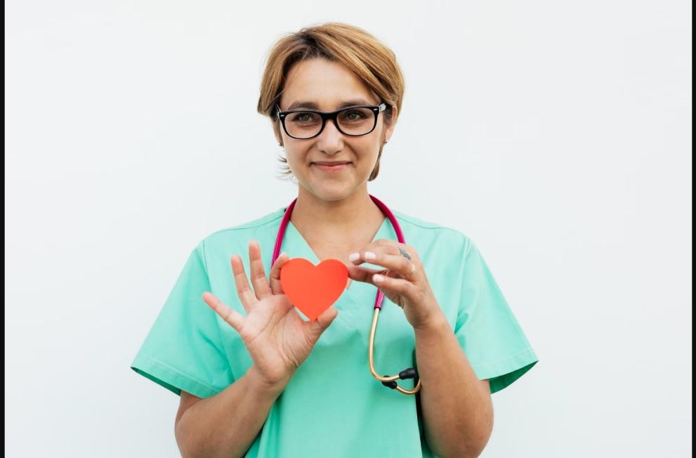 Healthcare provider holding a heart-shaped cutout with a stethoscope, representing cholesterol and cardiovascular risk assessment at Chinook Medical Centre Calgary
